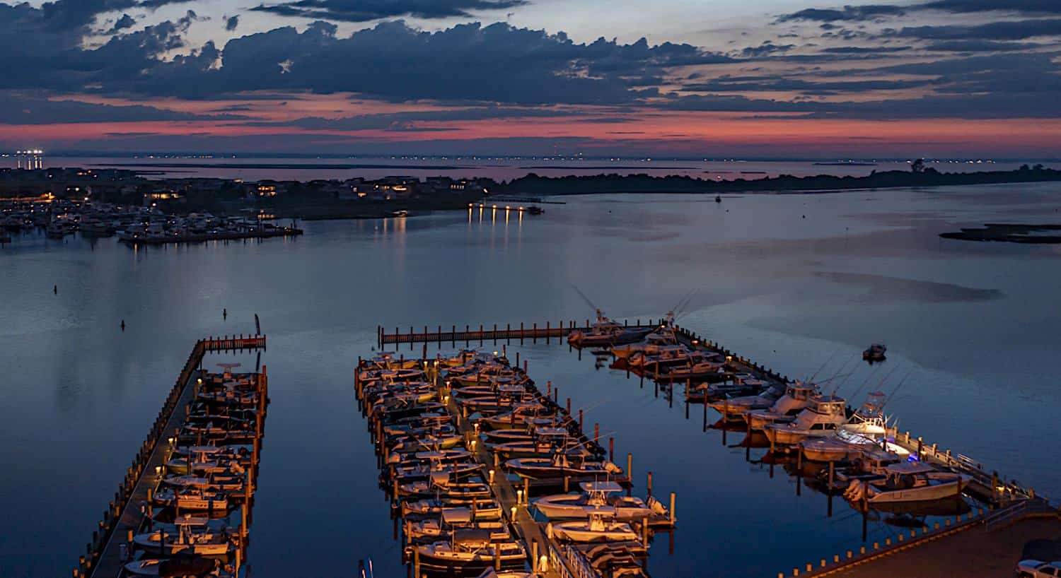 Aerial view of harbor full of boats in a coastal town at dusk
