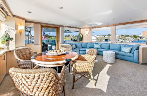 Large room on yacht with dining area, bar area, couch, TV and entertainment system