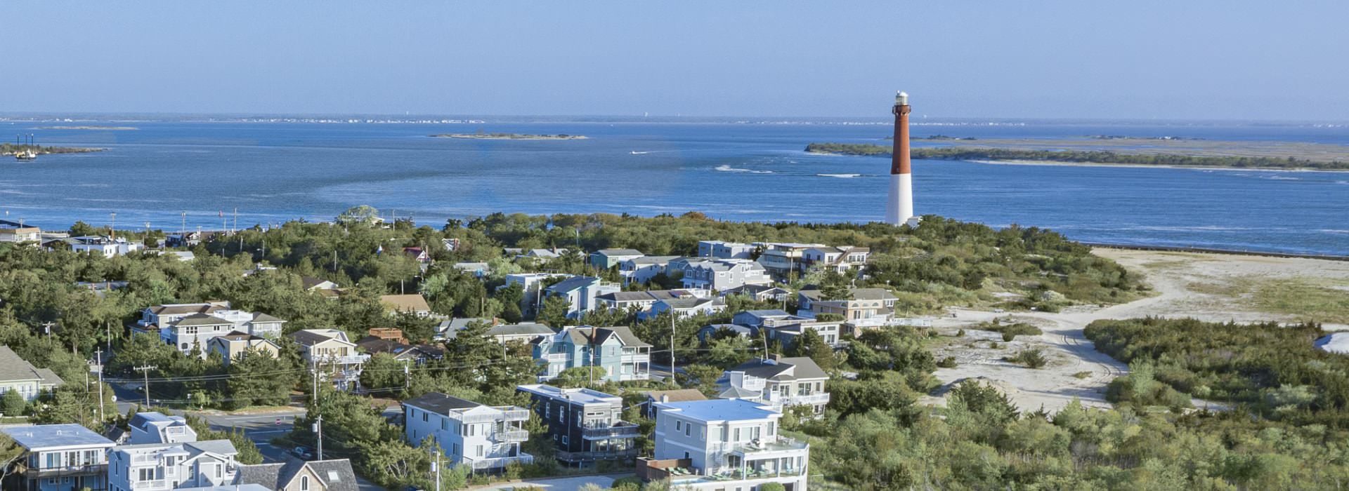 Aerial view of a coastal town with a lighthouse and ocean in the background