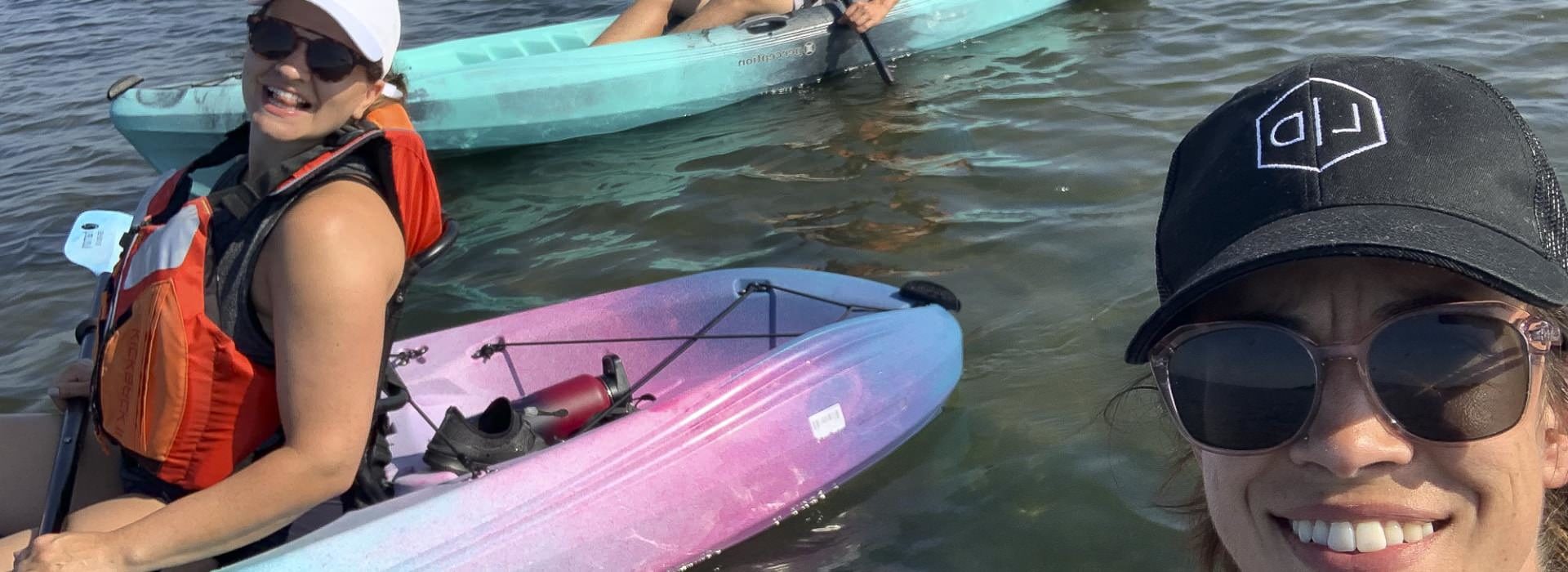 Close up view of women kayaking in multicolored kayaks