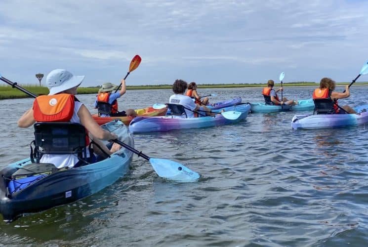 Multiple people kayaking out on the water