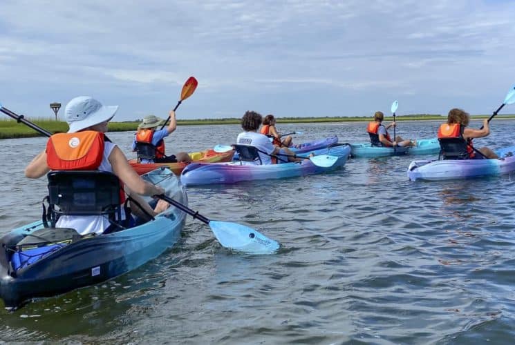 Multiple people kayaking out on the water