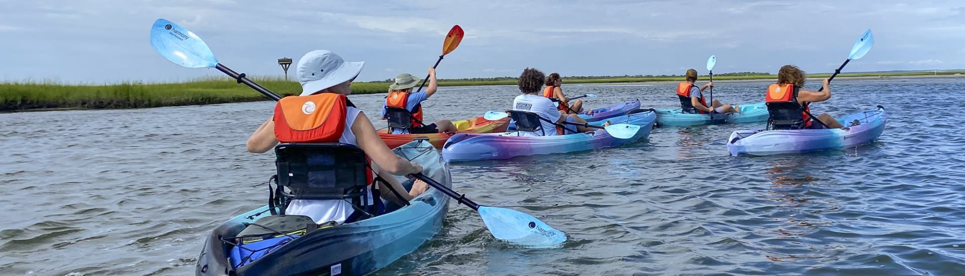 Multiple people kayaking out on the water