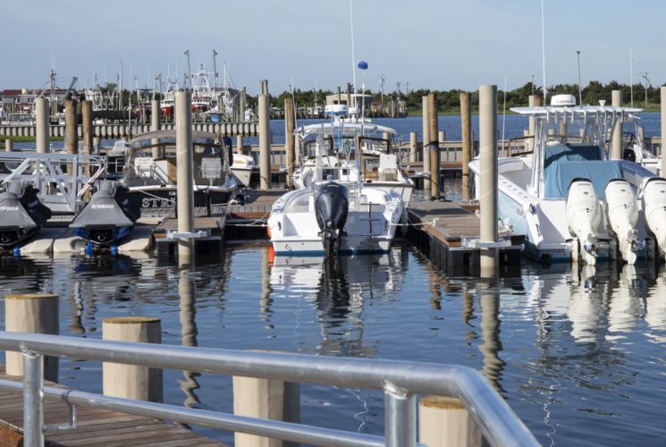 Multiple boats in slips and jet skis in ports in the harbor