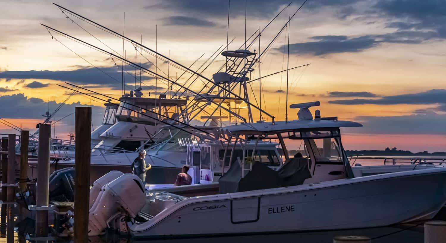 Multiple boats in slips in the harbor at dusk