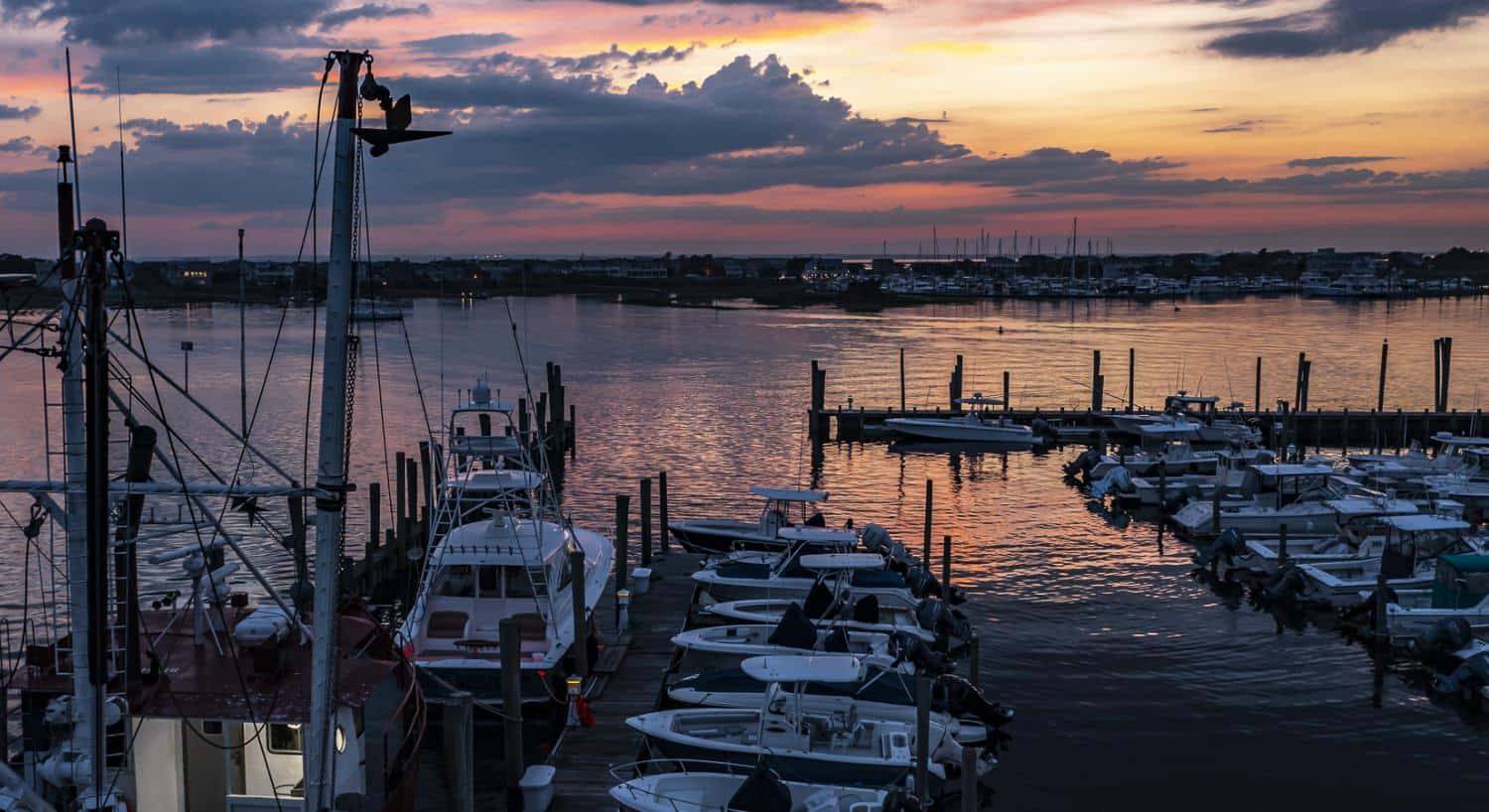 Multiple boats in slips in the harbor at dusk